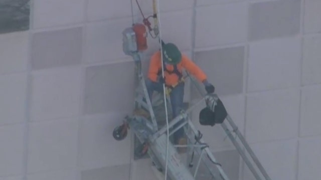 Workers dangle from building after scaffolding collapses