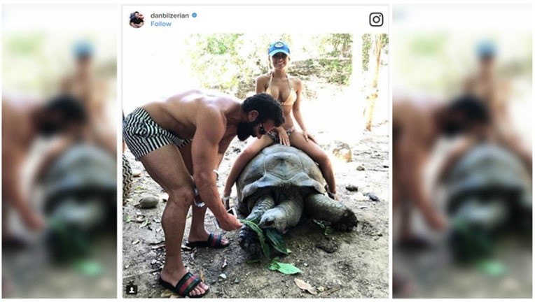 f7412566-Controversy over photo of bikini-clad woman on 100-year-old tortoise-404023