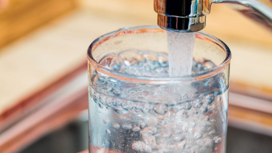 Filling up a glass with drinking water from kitchen tap