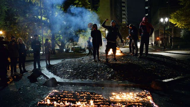 Riot declared in Portland as protesters smash windows