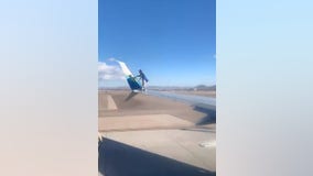 Man climbs onto commercial jet wing at Las Vegas airport, falls and gets arrested, videos show