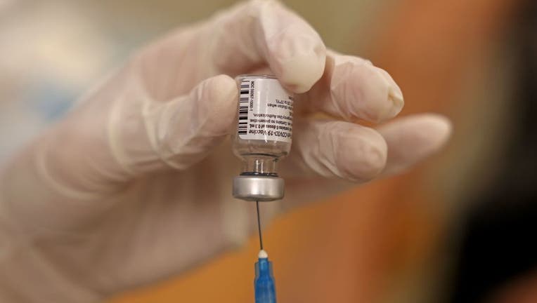 FILE - A health worker prepares a dose of the Pfizer-BioNTech COVID-19 vaccine at the Clalit Health Service in Jerusalem on August 1, 2021. (Photo by MENAHEM KAHANA/AFP via Getty Images)