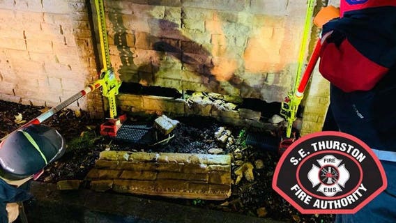 Person trapped climbing through parking lot wall, rescued by fire crew