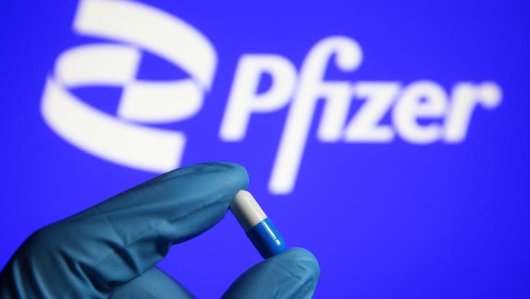 FILE - In this photo illustration, a medicine pill is seen in a hand dressed in a medical glove with a Pfizer logo in the background. (Photo Illustration by Pavlo Gonchar/SOPA Images/LightRocket via Getty Images)