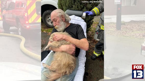 VIDEO: Man tries to run back into burning home to save dog, firefighter gets dog out