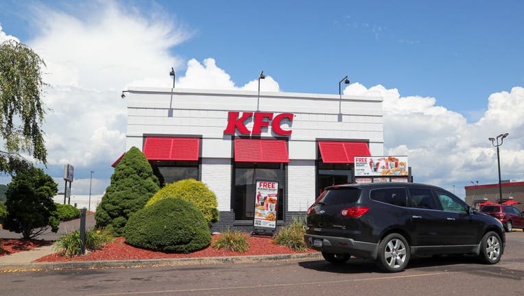 A car is stopped at the drive-thru of a KFC restaurant near