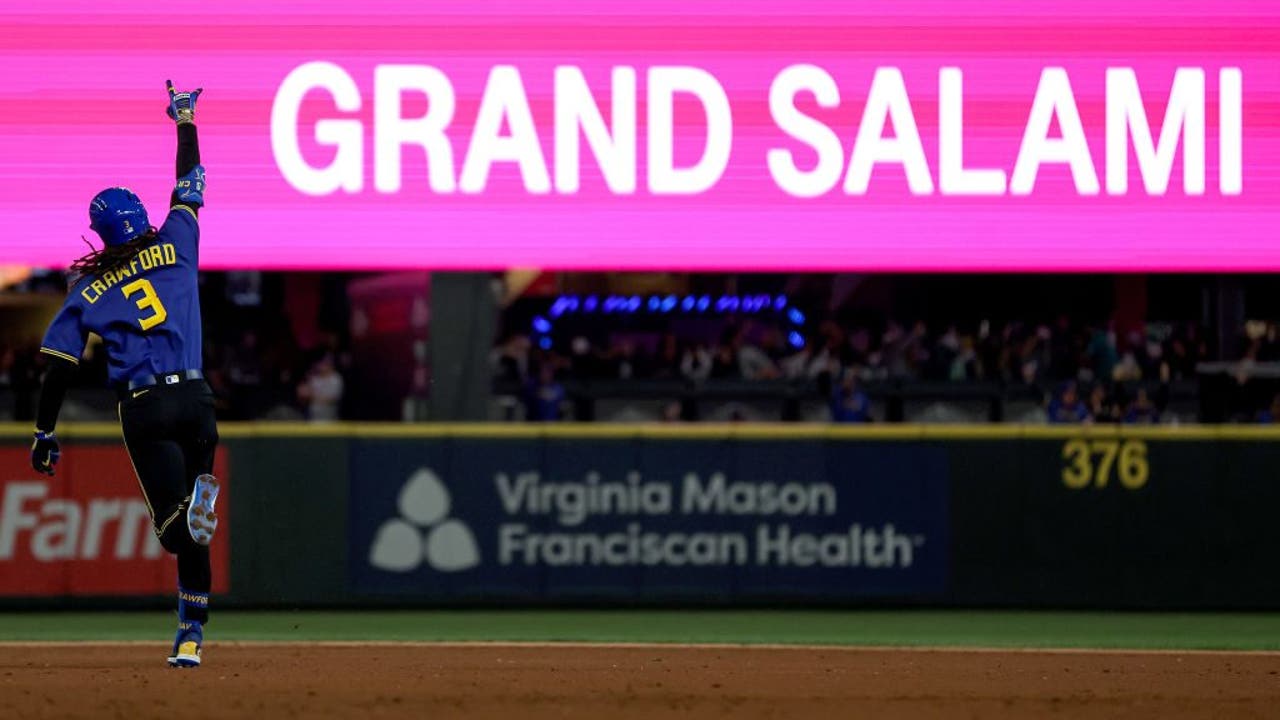 Seattle Mariners' J.P. Crawford, left, reacts after hitting a