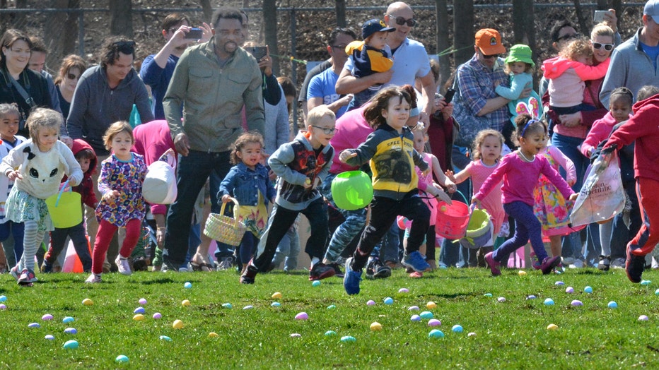 children dash across field during easter egg hunt