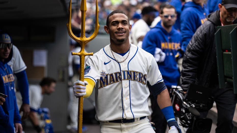 julio rodriguez holds trident in mariners dugout