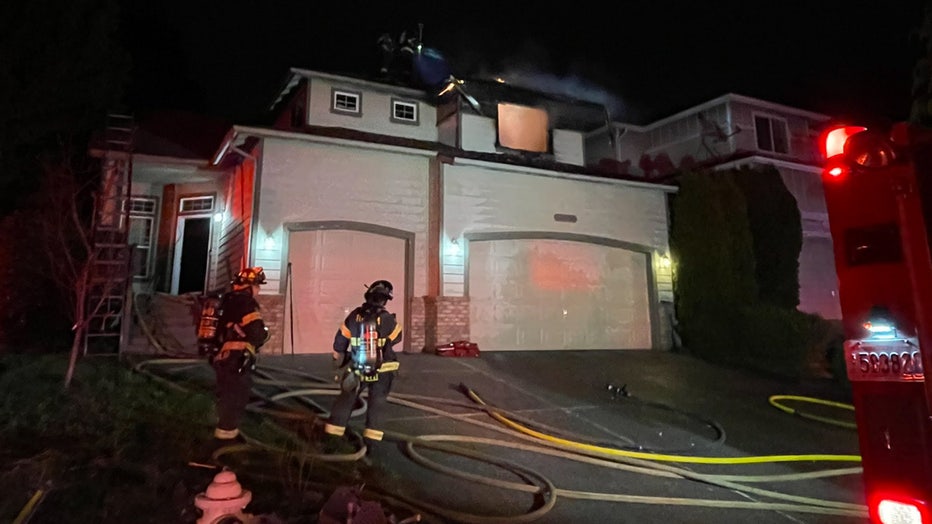 Firefighters working on a house fire in Kent overnight. Fire and smoke can be seen pouring out of the upstairs bedroom window. One person managed to escape the fire by climbing on the roof.