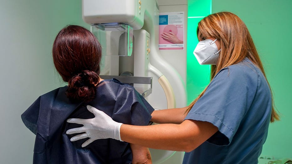 young woman receiving mammogram with nurse
