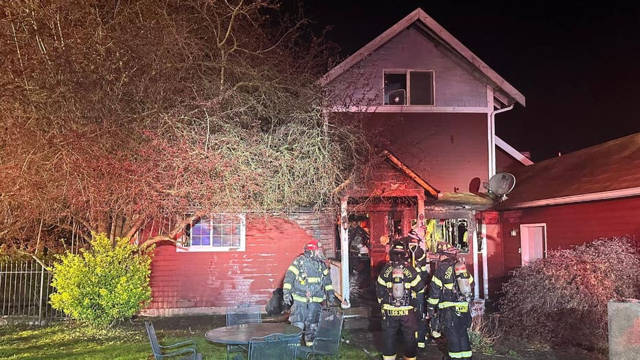 photo taken overnight showing firefighters at the scene of a house fire in Everett, Washington. 10 people living inside the home were displaced.