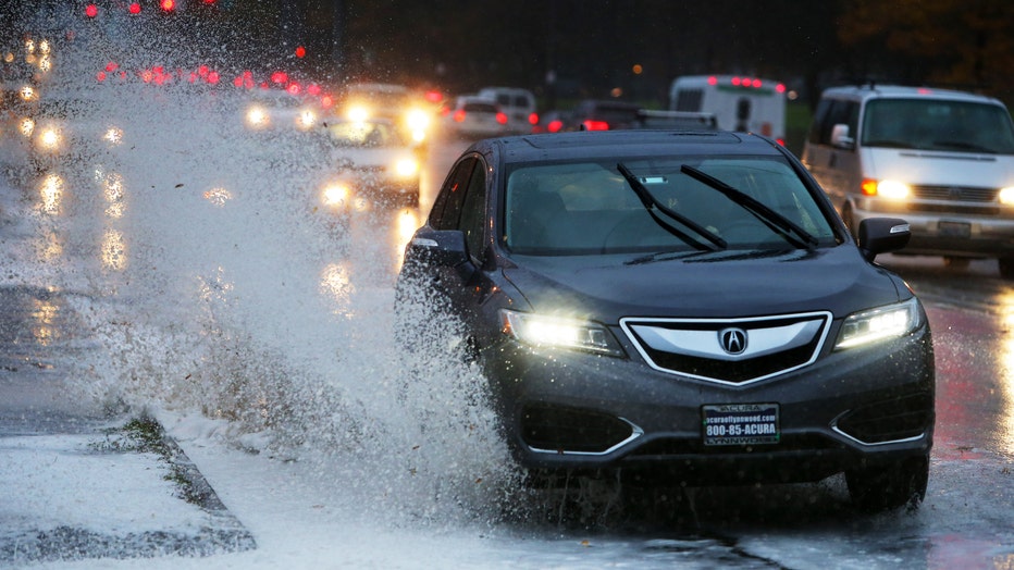 car drives through big puddle on road