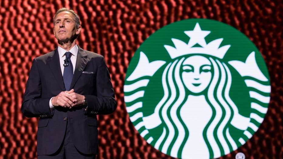 howard shcultz in front of starbucks logo