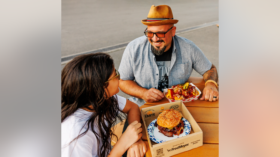 two people eating food at picnic table