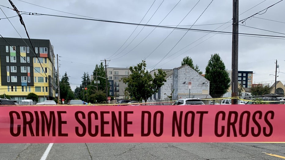 Red caution tape marks the perimeter of the scene in Seattle's Lake City neighborhood where police are investigating a deadly vehicular homicide.