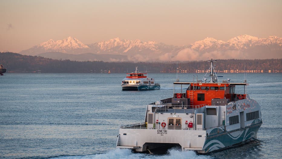 fast ferries sailing across washington puget sound sunset ocean mountains in background cascade mountain range