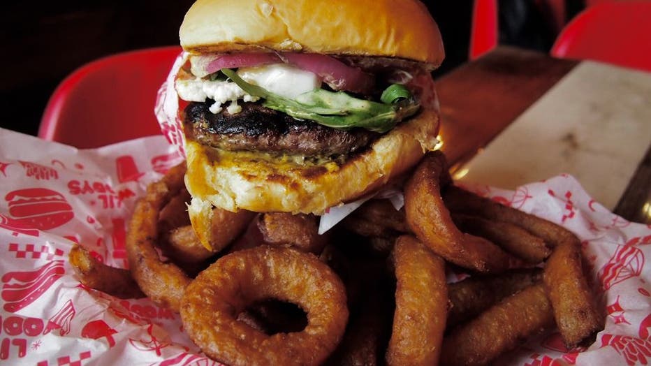 burger and onion rings in a red basket