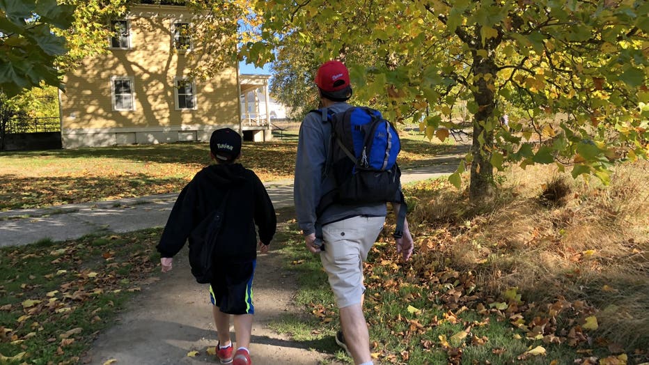 a man and child hiking with fall leaves