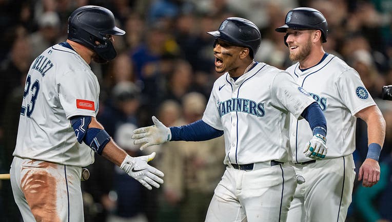 SEATTLE, WA -MARCH 27: Jorge Polanco #7 of the Seattle Mariners celebrates with Rowdy Tellez #23, left, and Luke Raley #20 after hitting a two-run home run during the eighth inning against the Athletics on Opening Day at T-Mobile Park on March 27, 2025 in Seattle, Washington. (Photo by Stephen Brashear/Getty Images)