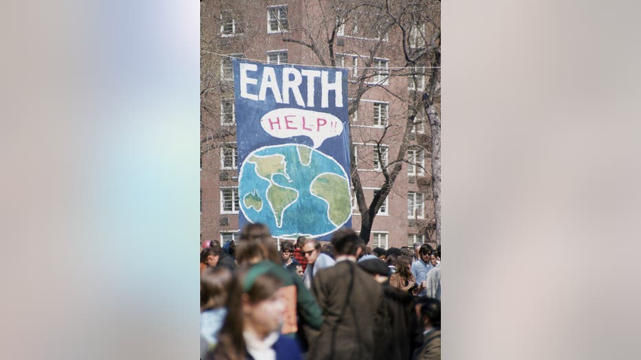 Hand painted sign showing the Earth with a talking box that reads "HELP" on the first Earth Day in 1970
