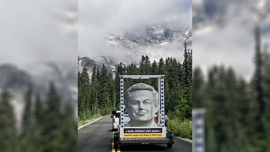 white elon musk statue in the back of a trailer