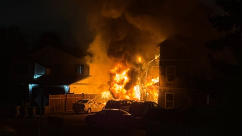 Seven people were displaced after a fire spread to two houses in Tacoma Friday morning. According to the Tacoma Fire Department (TFD), the fire was first called in at around 5:40 a.m. When crews arrived they found that flames from the attic of one home had spread to the house next door – which was vacant and listed for sale. Relatives in the house said they heard the fire alarms go off, and saw the fire when they went into the garage. The fire spread to multiple units inside the home and parked cars in the driveway. Crews say seven people were inside the home during the fire, and all managed to get out safely. The Red Cross is helping them with housing. The cause of the fire remains under investigation.