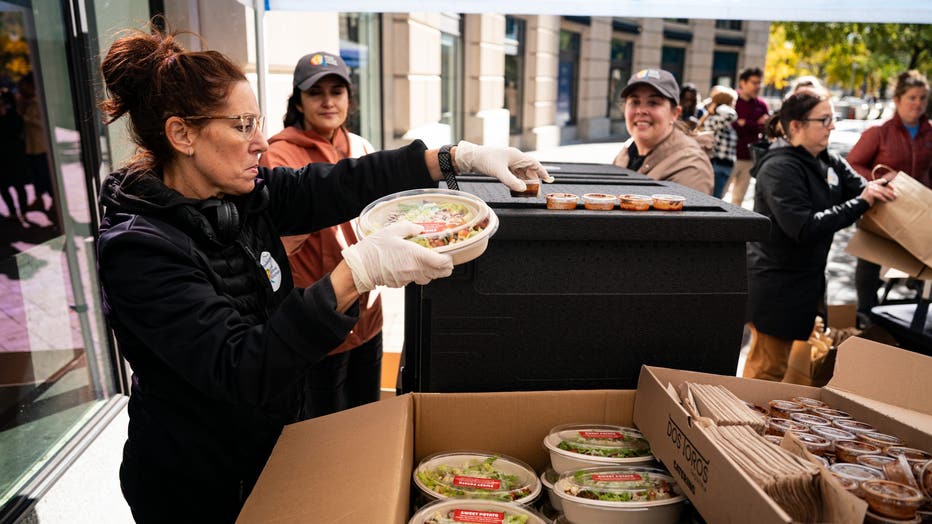 woman passes out free salads