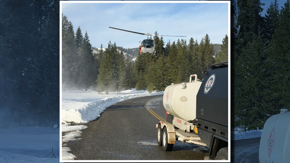 a rescue helicopter flies over a snowy mountain area in kittitas county washington after a deadly avalanche