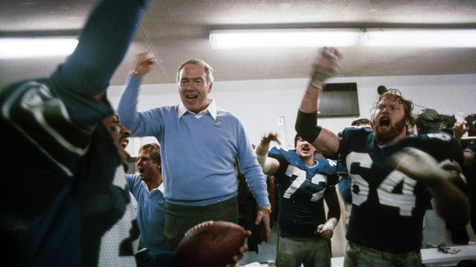 Dave Brown handing game ball to Chuck Knox
