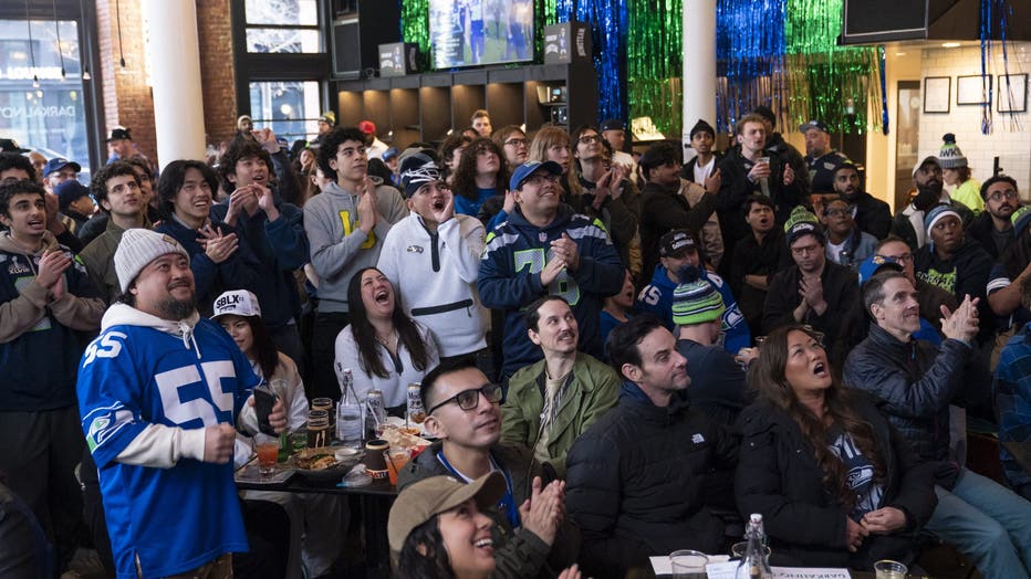 seahawks fans in a bar watching the super bowl