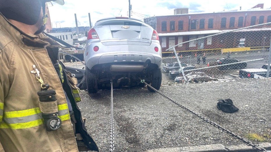 rescue teams in tacoma help save a driver dangling over a 20-foot concrete drop