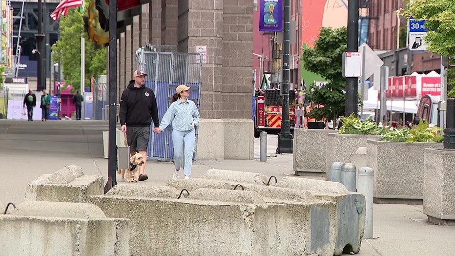 a couple in Seattle walks near the stadium district where there is an "unprecedented" security effort being constructed for the fifa world cup 2026 matches