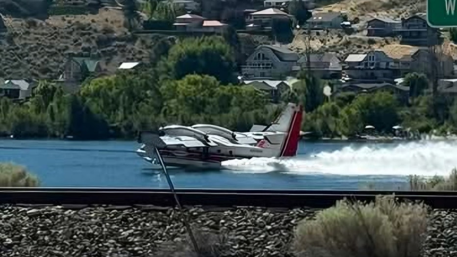 Firefighting planes scoop water to battle the Chelan Hills fire in Douglas County, Washington near Lake Chelan on July 4, 2026