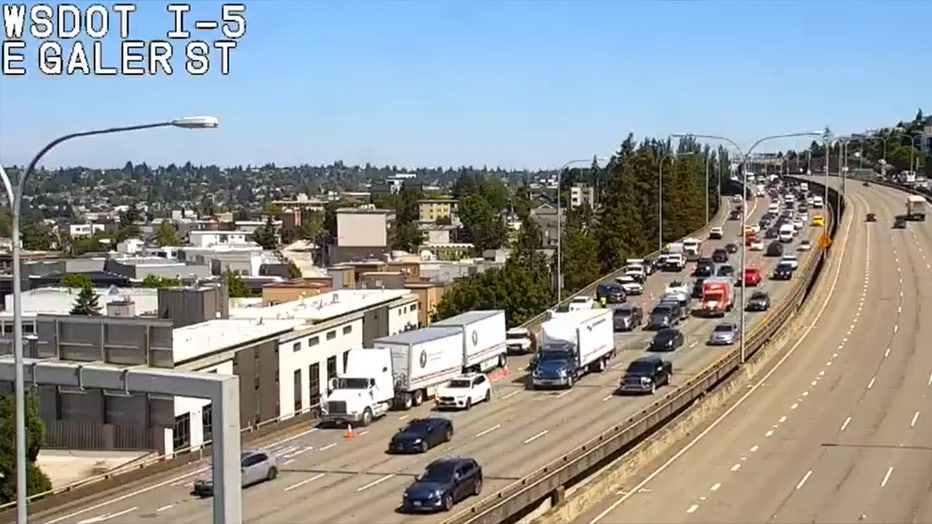A collision on southbound Interstate 5 on Monday morning sent a loose semi-truck tire and debris falling into Seattle's Eastlake neighborhood. The runaway tire bounced into an apartment building, cracking a window and damaging a parked car's side mirror. No injuries were reported, but Washington State Patrol and emergency crews remain on the scene, causing traffic delays near the Boylston Avenue on-ramp.