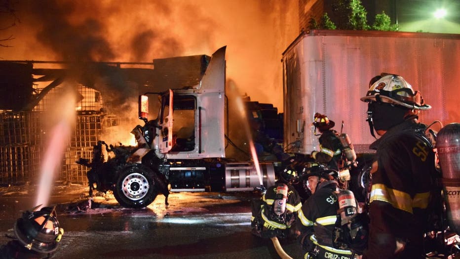 A three-alarm commercial warehouse fire broke out in Seattle's Industrial District early Wednesday morning, drawing more than 100 emergency personnel to the scene. Crews fought the flames defensively due to unidentified barrels found near the building, prompting officials to issue a shelter-in-place advisory for nearby residents. No injuries were reported, and investigators are working to determine what sparked the blaze after the warehouse roof collapsed.