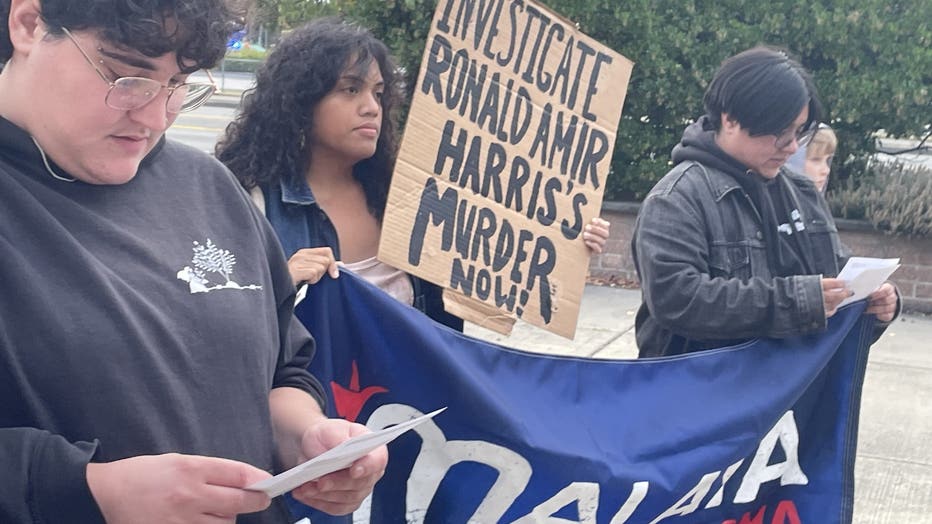 Group holds signs outside of Tacoma Police Department.