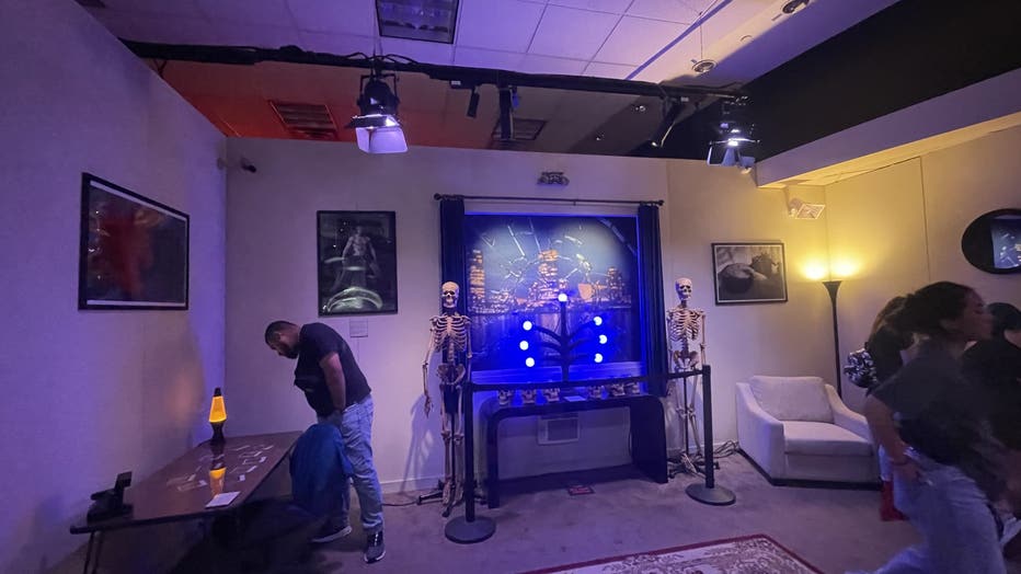 Visitors look at pictures of victims in replica of Jeffrey Dahmer's apartment.