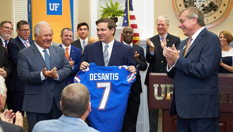 Gov. Ron DeSantis holds up a Florida Gators jersey during his September 2019 announcement of the university's #7 ranking in US News' list of the country's best colleges. (Courtesy: University of Florida/Twitter)