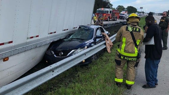 PHOTOS: Semi truck pins car against guardrail after tire blowout, Florida officials say
